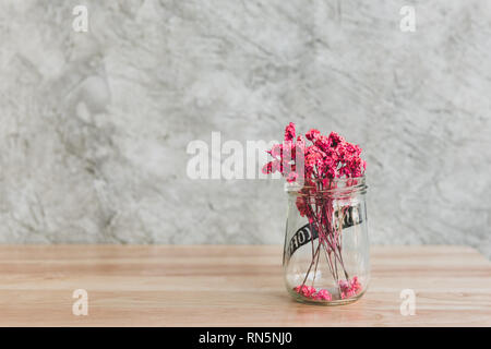 Bella rosa fiori secchi nel vaso di vetro decorato sul tavolo di legno nel caffè cafe Foto Stock