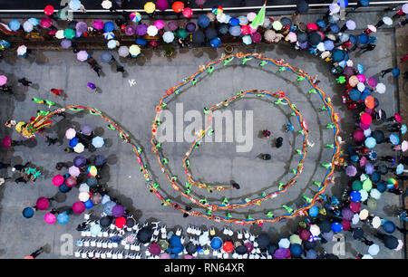 Hangzhou (Cina). Xvii Feb, 2019. Foto aerea mostra elementi di una femmina rurale dancing team di eseguire in legno con panca dragon dance per celebrare la prossima Lanterna cinese Festival, che cade il 19 febbraio di quest'anno, al Villaggio Yaokou di Huyuan township di Hangzhou, città capitale della Cina dell'est della provincia di Zhejiang, nel febbraio 17, 2019. Villaggio Yaokou è famosa per il suo legno-panchina dragon dance, che è originata dalla Dinastia Qing (1644-1911). Il legno del banco-drago è lunga 130 metri con 58 panche di legno legati insieme, sul quale i vari lanterna decorazioni sono installati. Peopl Credito: Xinhu Foto Stock