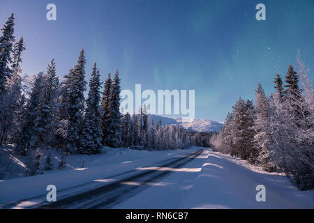 Una strada che porta verso la coperta di neve Pallas cadde nella notte invernale in Pallas-Yllästunturi parco nazionale di Muonio in Finlandia Foto Stock