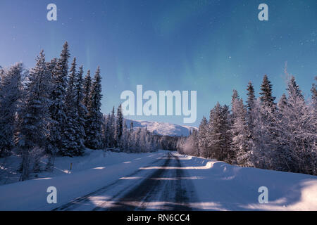 Una strada che porta verso la coperta di neve Pallas mountain durante la notte invernale in Pallas-Yllästunturi parco nazionale di Muonio in Finlandia Foto Stock