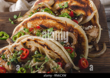 Una delizia cibo casereccio taco gusci, freschi peperoncino piccante e di pollo con erbe e cipolla, preferito bere freddo Foto Stock