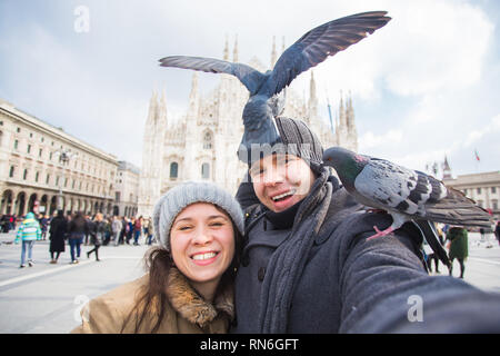 Viaggi, Italia e divertente giovane concetto - Happy turisti prendendo un autoritratto con piccioni nella parte anteriore del Duomo di Milano Foto Stock