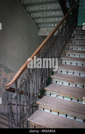 Scala in legno alla luce del giorno con battistrada usurato in un Tenement House Foto Stock