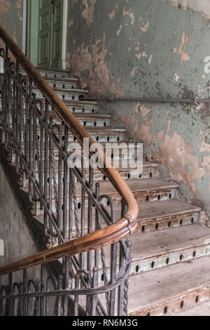 Vecchia scalinata in legno che porta in una stanza di un casamento blocco Foto Stock