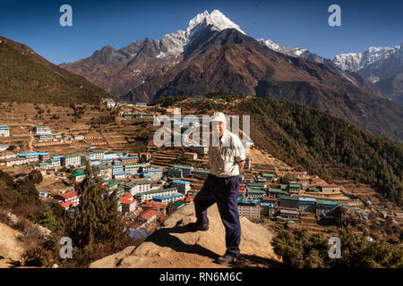 Il Nepal, Namche Bazaar, senior tourist sopra la città con Snow capped Mt Thamserkhu dietro di picco Foto Stock