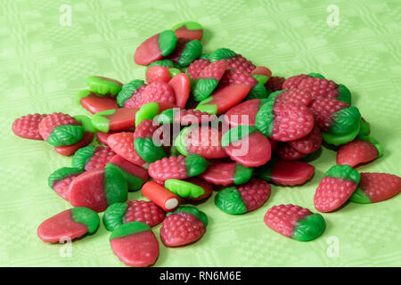 Caramelle colorate fragole sulla luce tovaglie verde dello sfondo. Foto Stock