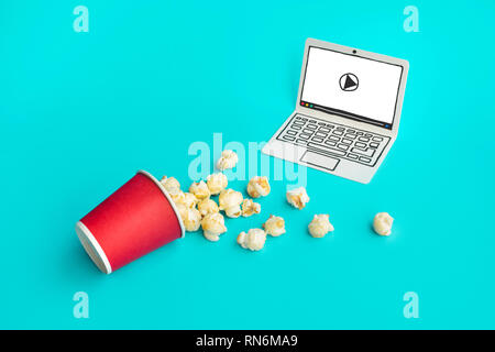 Pop corn con carta tecnica su notebook color pastello sfondo.il cibo e snack,live stream entertainment.concetti idee.Stile minimal Foto Stock
