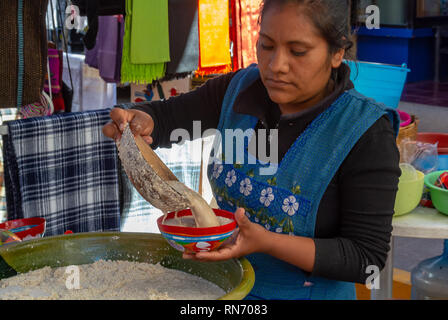 Una donna locale che serve Tejate, bevanda tradizionale a base di cacao e mais per dio al mercato di Tlacolula, Oaxaca de Juárez, messico Foto Stock