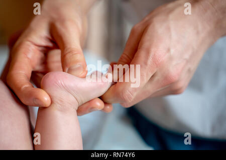 Immagine di mani del terapista di massaggio rendendo massaggio ai piedi per il bambino piccolo. Foto Stock