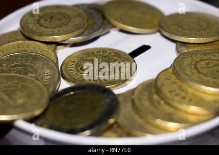 Il peso delle monete in un salvadanaio Foto Stock