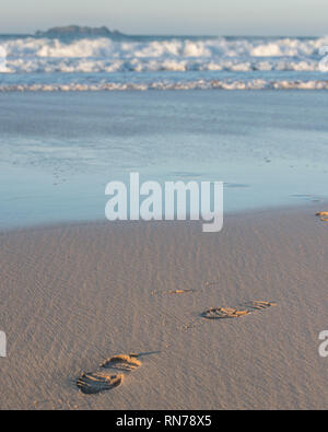 Orme nella sabbia dal mare Foto Stock