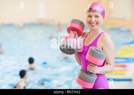 Senior donna esercita da piscina Foto Stock
