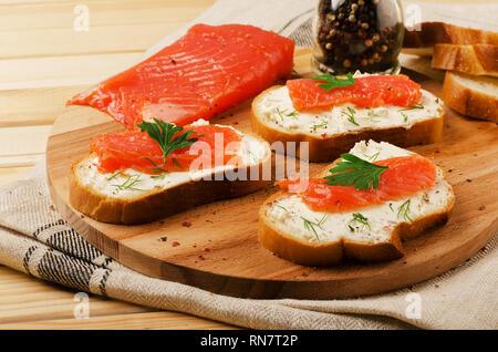 Antipasto con salmone e formaggio crema su un tagliere Foto Stock