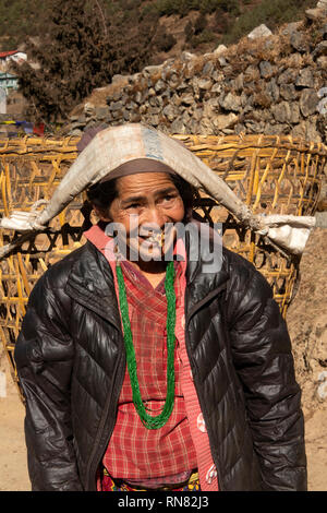 Np1017 Nepal, Namche Bazaar, turismo, femmina Sherpa con naso anello cestello di trasporto utilizzando tumpline fronte cinturino Foto Stock