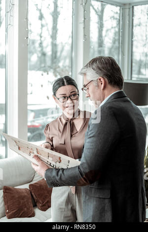 Dai capelli scuri donna elegante in un marrone camicetta in raso cercando incerta Foto Stock