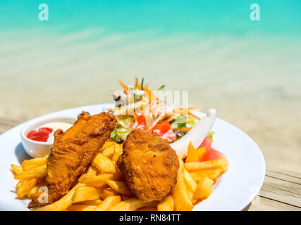 Cibo tropicale di grigliate di pesce e verdure pietanza servita sull isola tropicale in Laguna Aitutaki, Isole Cook. Con il fuoco selettivo Foto Stock