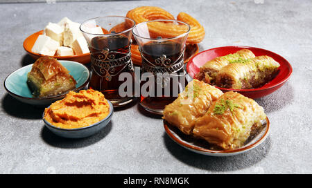 Medio orientale o piatti arabi e un assortimento di meze, concreto sfondo rustico. sambusak. Dolce turco Baklava con pistacchio. Cibo Halal. Libanesi Foto Stock
