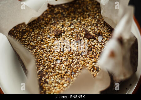 Primo piano Il lusso artigianale di cioccolato fondente con seasame e sale marino, nella carta Foto Stock