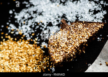 Il lusso artigianale di cioccolato fondente con seasame e sale marino, sfondo nero Foto Stock