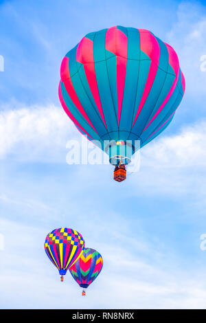 Raggruppamento di tre i palloni ad aria calda contro il cielo blu in verticale. Foto Stock