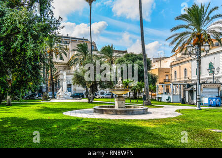 Una vista dell'acqua della fontana e la statua commemorativa presso la Piazza Vittorio Emanuele II lungo la costa del Mare Adriatico a Brindisi, Italia Foto Stock