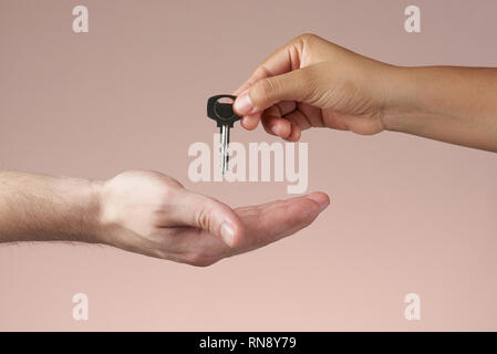 Donna consegna a mano chiave per man mano. Dando a mano house o la chiave della camera. Foto Stock