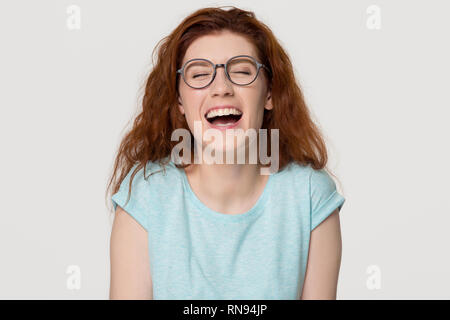 Allegro felice i capelli rossi giovane donna in bicchieri di ridere a voce alta Foto Stock