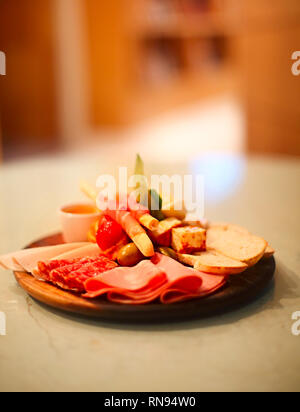 Mix di tradizionale prosciutto spagnolo salame, prosciutto di Parma su grissini verdure marinate e olive sul piatto di legno con decorazioni rustiche. Notte pa Foto Stock