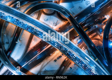 Vista aerea di strada nella città moderna in una notte d'inverno. Vista superiore del traffico in autostrada con illuminazione della città. Vetture su strada sopraelevata Inte Foto Stock