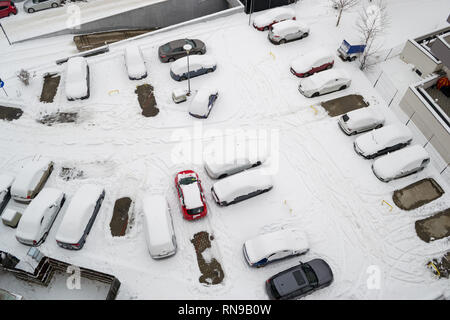 Vista aerea di un urbano parcheggio in una zona residenziale, dopo una neve pesante, con vetture coperte di neve e qualche vuoto posteggi. Gennaio 2019 Foto Stock