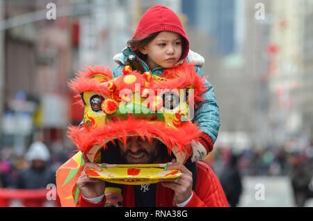 Un uomo che indossa un costume da drago vede tenendo il suo figlio durante il Nuovo Anno Cinese Parade di Chinatown. Le comunità cinesi di tutto il mondo ha festeggiato il nuovo anno cinese 2019, anno del maiale. Foto Stock