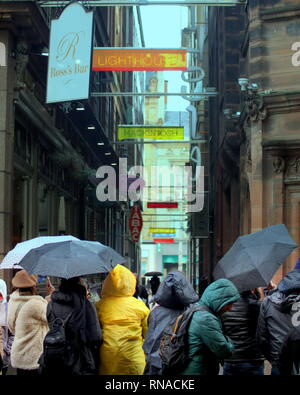 Glasgow, Scotland, Regno Unito 18th, febbraio 2019 UK Meteo: il faro di Mitchel street Rainy day come la gente del posto e i turisti godere dei loro ombrelloni.Credit Gerard Ferry/Alamy Live News Foto Stock