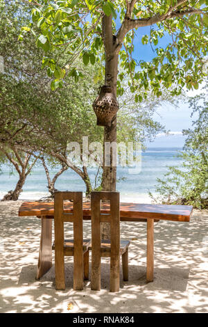 Posti a sedere in legno gruppi sulla spiaggia di Gili Trawangan, Indonesia. Foto Stock