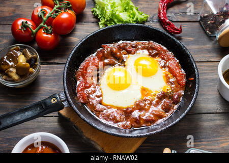 Shakshuka, uova fritte in salsa di pomodoro in ferro padella. Israele tipico cibo. Foto Stock