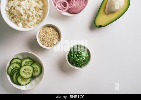 Piatti a base di frutti di mare freschi ricetta. Salmone gamberetti poke ciotola con gamberi freschi, riso, cetrioli, decapare la cipolla dolce, Rafano, i fagioli di soia edamame porzionato con bl Foto Stock