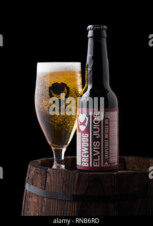 LONDON, Regno Unito - 06 febbraio 2019: bottiglia e bicchiere di Elvis Succhi di pompelmo IPA birra, dal birrificio Brewdog sul vecchio Barile di legno su sfondo nero Foto Stock