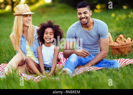 Immagine della coppia adorabile con la loro figlia avente picnic Foto Stock