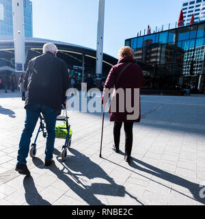 Silhouette di vecchio uomo dietro walker e donna con bastone Foto Stock