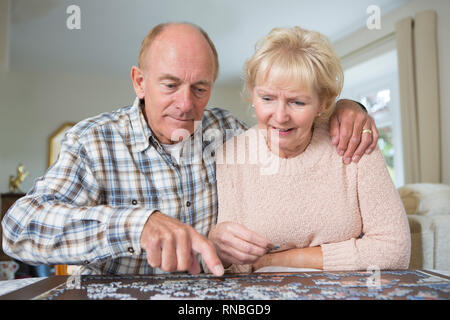 Coppia senior a casa facendo Puzzle insieme Foto Stock