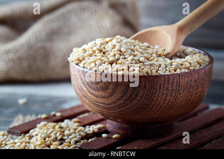 Raw granella di orzo (Hordeum vulgare) nella ciotola di legno Foto Stock