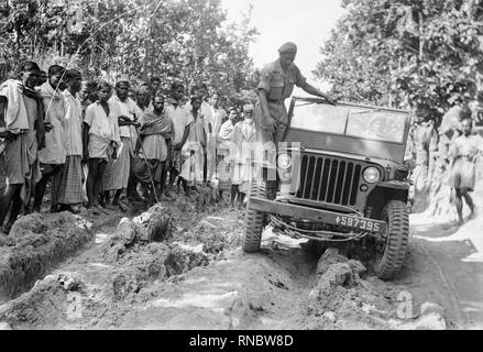 Una Willys MB Jeep in fase di collaudo da parte indiana forze militari verso la metà del ventesimo secolo. La popolazione locale a guardare. Foto Stock