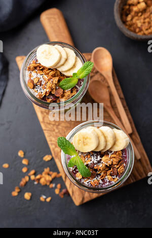 Granola Banana Prima colazione in vaso su legno scheda servente, vista dall'alto Foto Stock