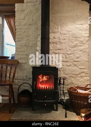 Nero piccolo camino nella casa pareti bianche fuoco aperto Foto Stock