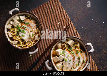 Asian miso di spaghetti ramen con pollo e tofu. Sfondo scuro. Foto Stock