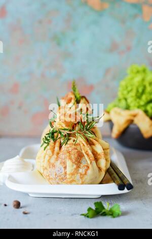 Scotch le uova in un sacchetto di frittelle con verdi su un colore grigio-blu sullo sfondo. Un piatto classico in un bizzarro che serve. Delizioso e appetitoso piatto di Brit Foto Stock