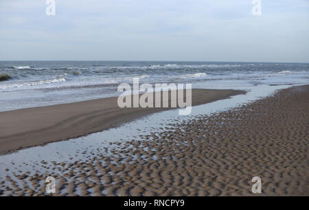 Spiaggia e mare del Nord nei Paesi Bassi con la bassa marea. increspature dell'acqua dà belle strutture in sabbia. Foto Stock