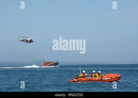 Il Selsey scialuppa di salvataggio e soccorso dinghy raffigurata con HM elicottero Guardia costiera a Selsey scialuppa di salvataggio giorno nel mese di agosto 2018 Foto Stock