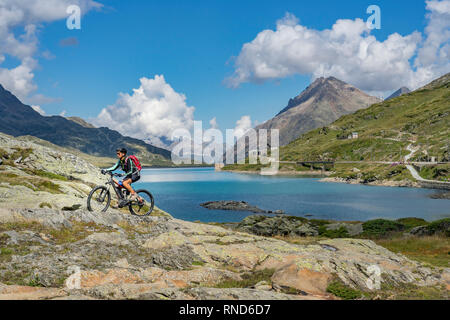 Donna senior, equitazione il suo e-mountainbike sul famoso Bernina Express trail a Lago Bianco, Passo Bernina vicino a Pontresina un St.Moritz Engadin, Switze Foto Stock