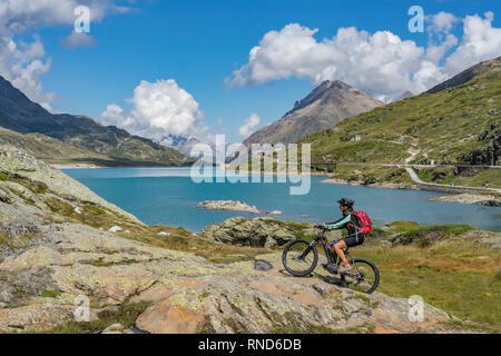 Donna senior, equitazione il suo e-mountainbike sul famoso Bernina Express trail a Lago Bianco, Passo Bernina vicino a Pontresina un St.Moritz Engadin, Switze Foto Stock