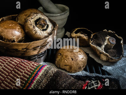 Cesto di funghi freschi fotografia scuro Foto Stock